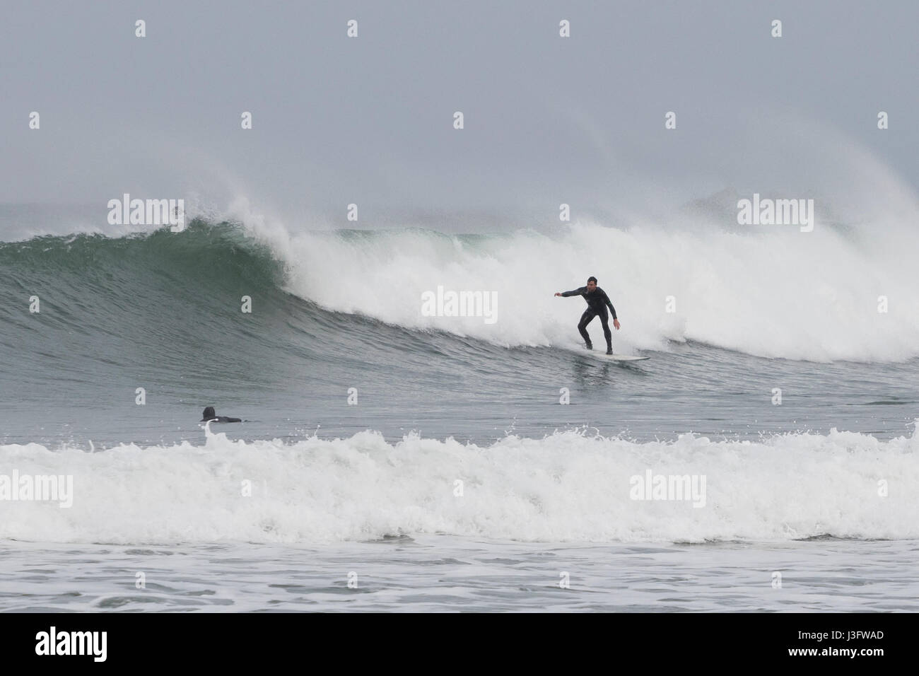 Male surfer surfing a broken wave in La Zurriola beach (San Sebastian, Spain). Stock Photo