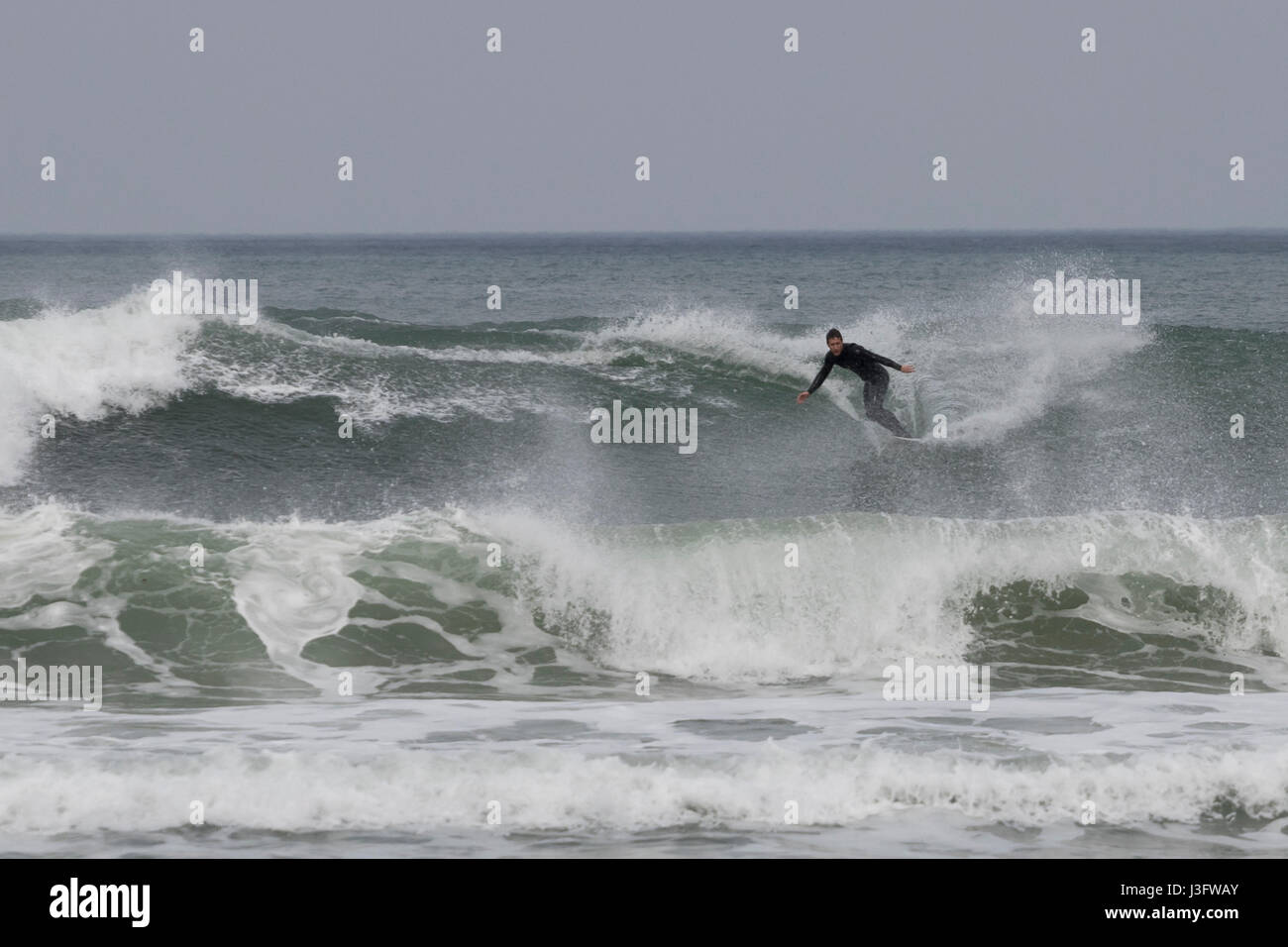 Surfer catching wild waves in La Zurriola beach in San Sebastian (Guipuzcoa, Spain) 2017. Stock Photo