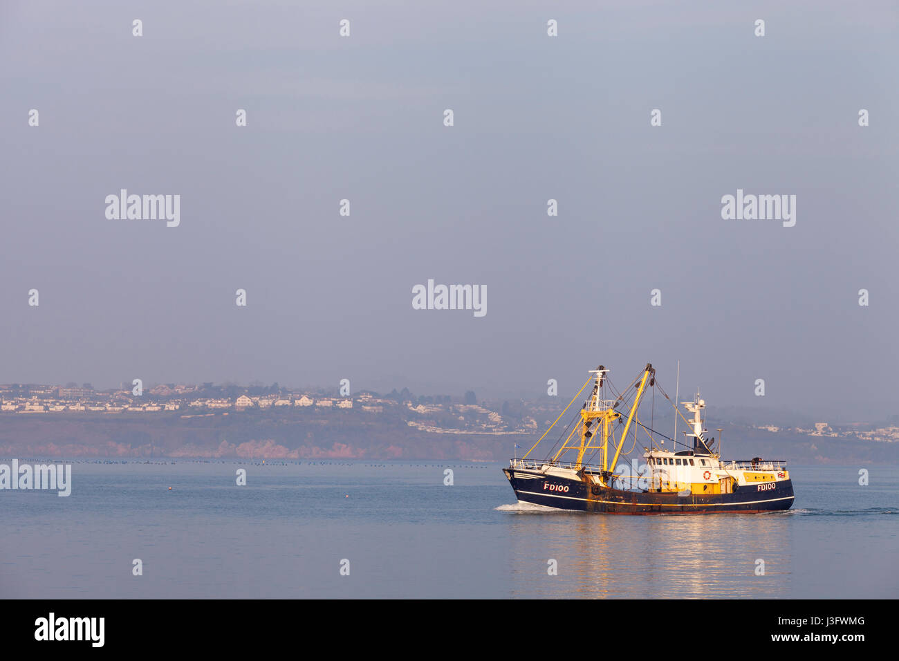 Commercial fishing boat (trawler) returning to Brixham harbour in  Devon, UK on a sunny  morning. Stock Photo