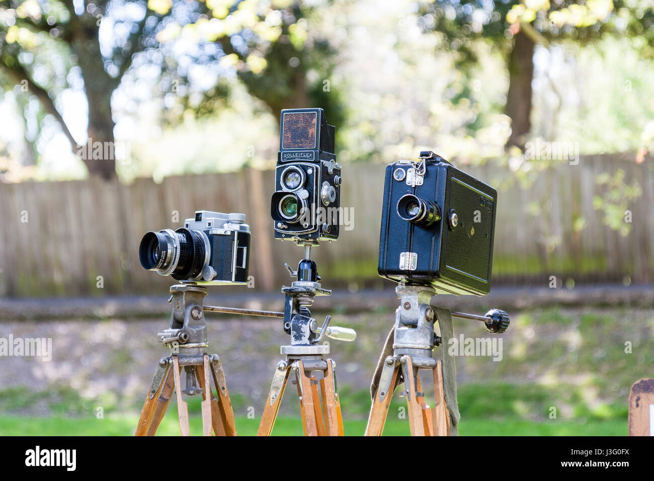 Salute to the 40's re-enactment event. Various vintage world war two cameras on wooden tripods set up in a row. Stock Photo