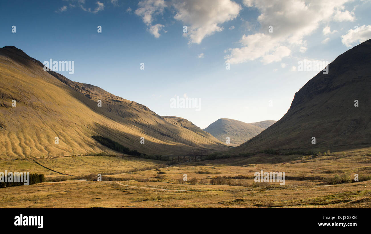 The West Highland Railway line the Highlands of Scotland winds around a broad valley near Bridge of Orchy. Stock Photo