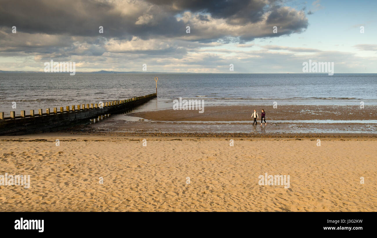A couple walking on the beach at Portobello on the Firth of Forth coast