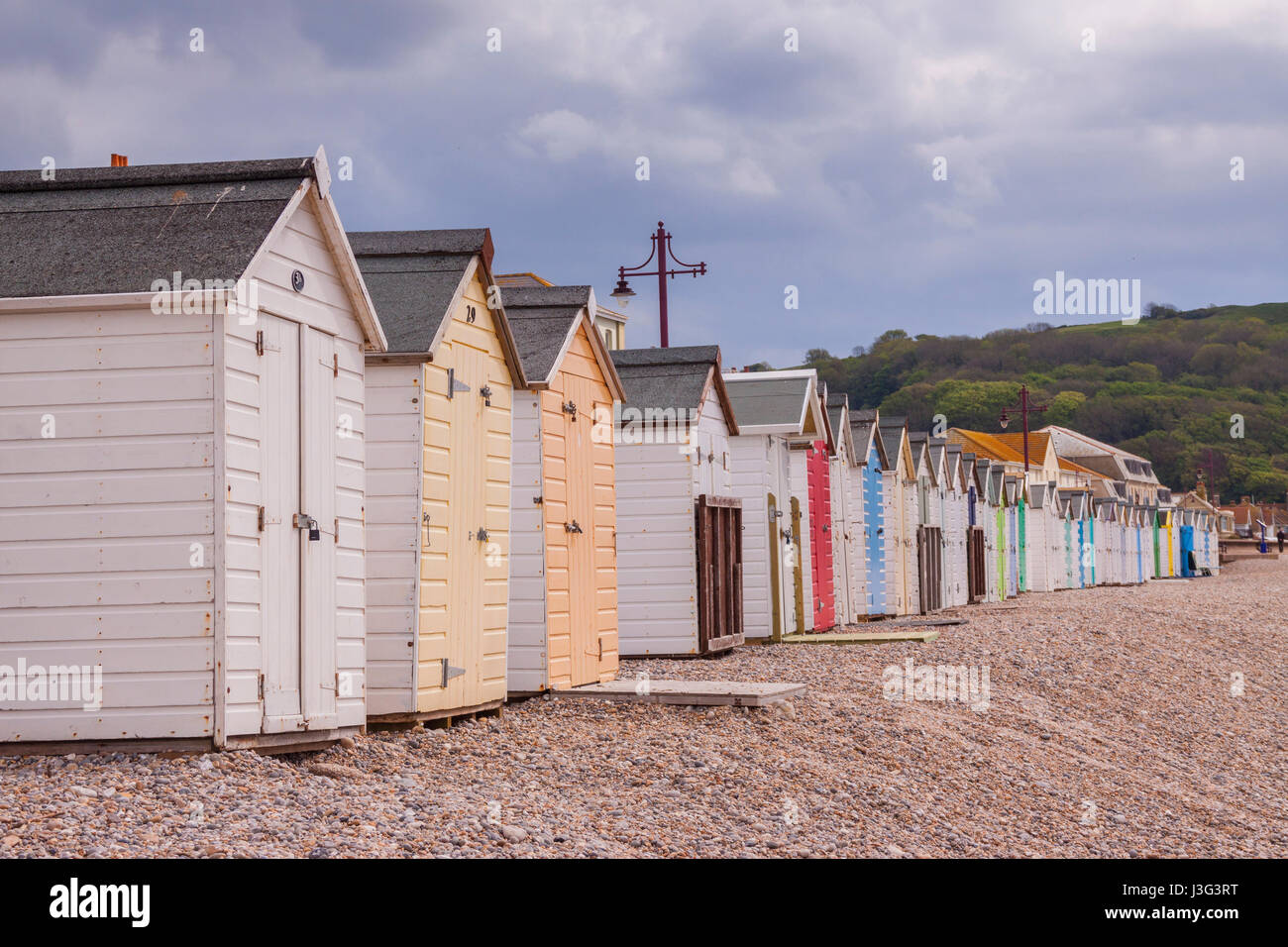 Beach huts on the beach at Seaton Devon, with blocks of flats behind