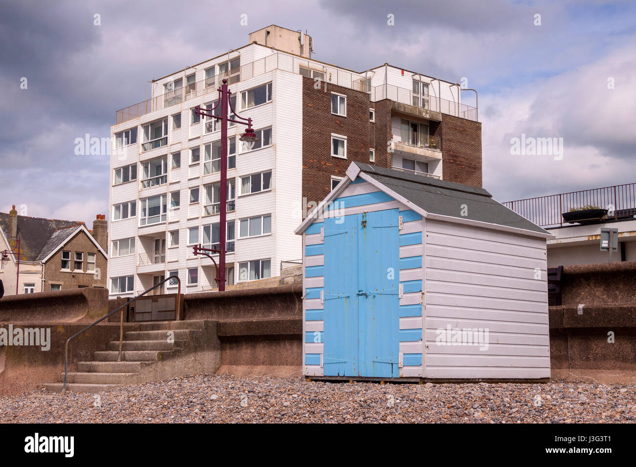 Beach huts on the beach at Seaton Devon, with blocks of flats behind