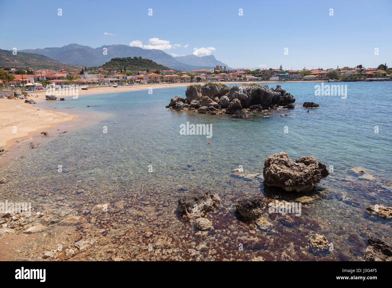 beautiful sandy beach of Stoupa in greece on sunny day in spring on peloponnese with mountains in the background Stock Photo