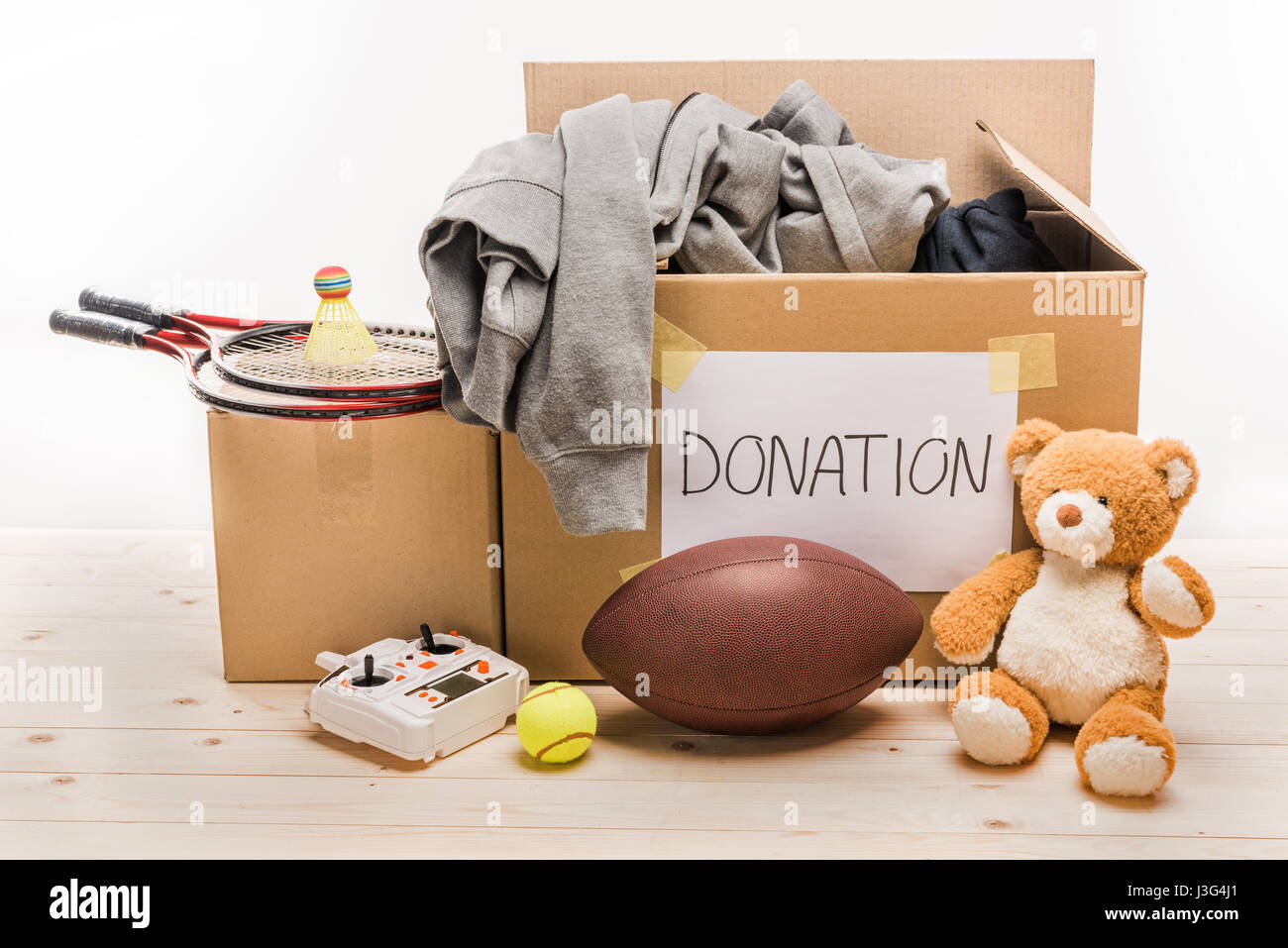 cardboard boxes with donation clothes and different objects on white, donation concept Stock Photo