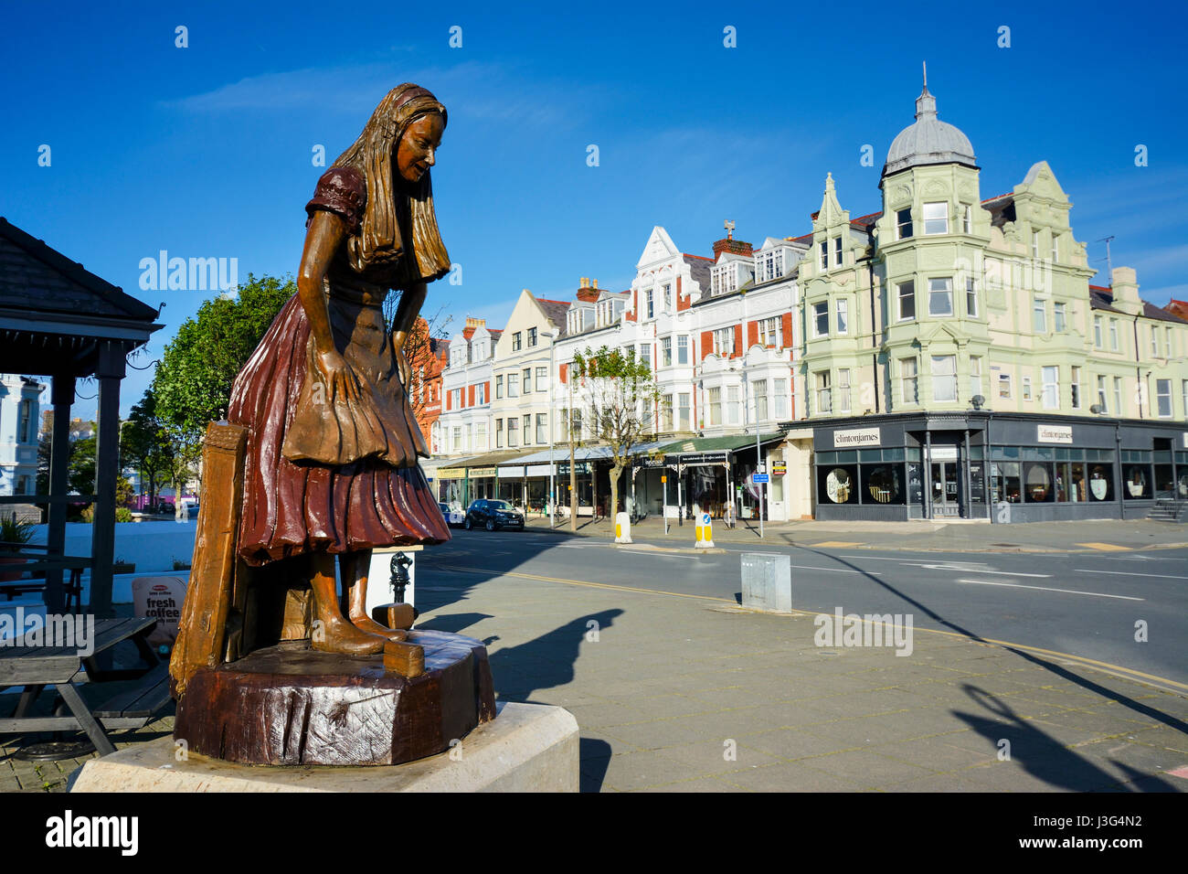 Alice in Wonderland carved wooden statue in Llandudno highlighting the connection to the town with Alice Pleasance Liddell, who the Alice in Wonderlan Stock Photo