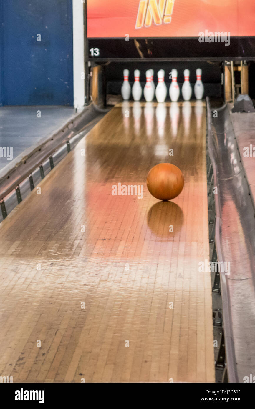 Bowling ball rolling towards skittles on ten pin bowling alley Stock Photo