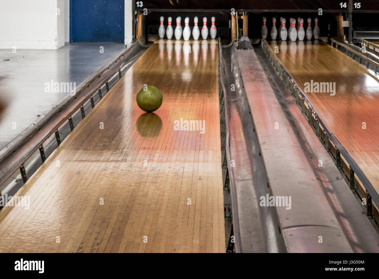 Bowling ball rolling towards skittles on ten pin bowling alley Stock Photo
