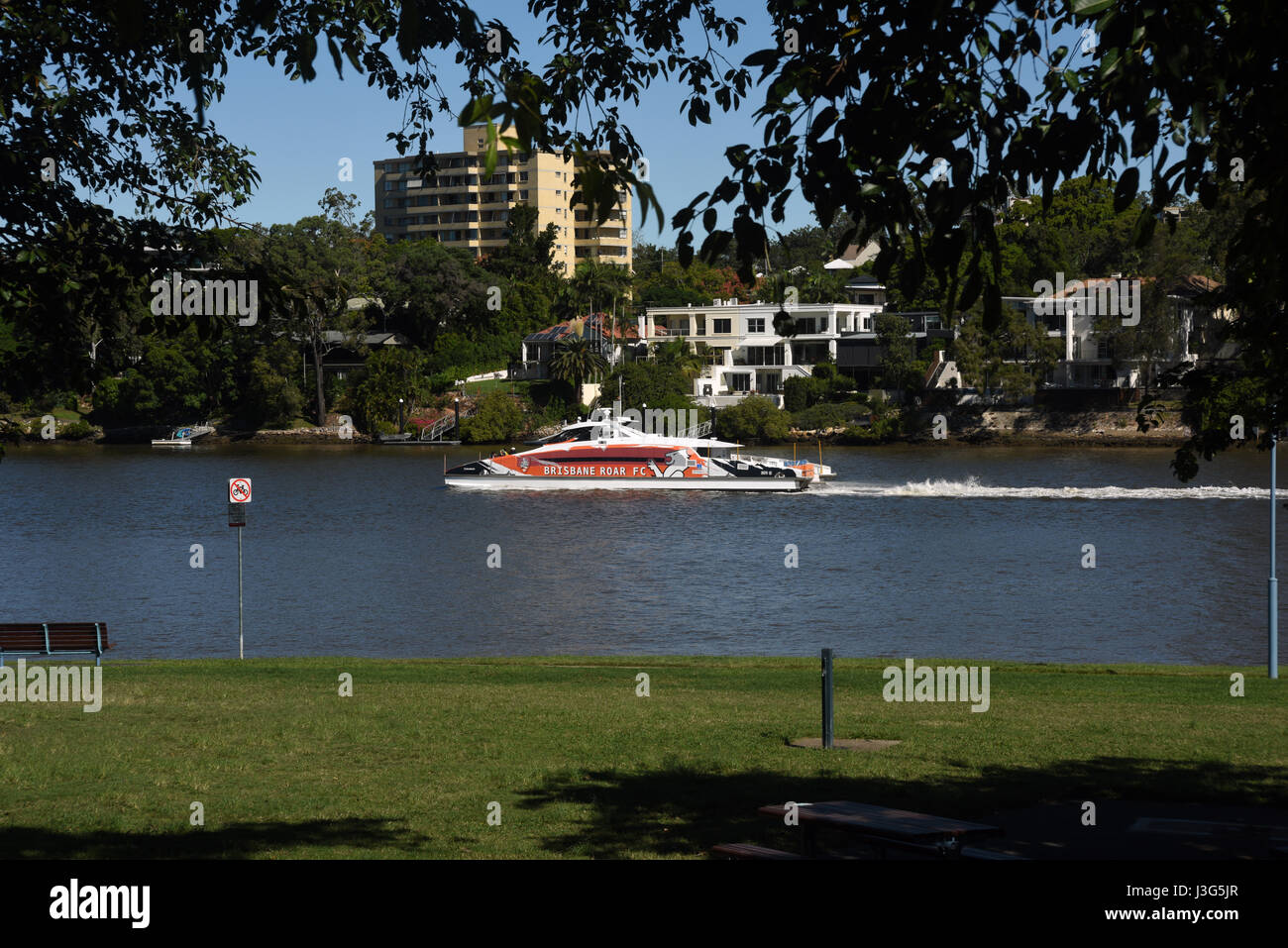 Brisbane, Australia CityCat ferry on Brisbane River passing homes and
