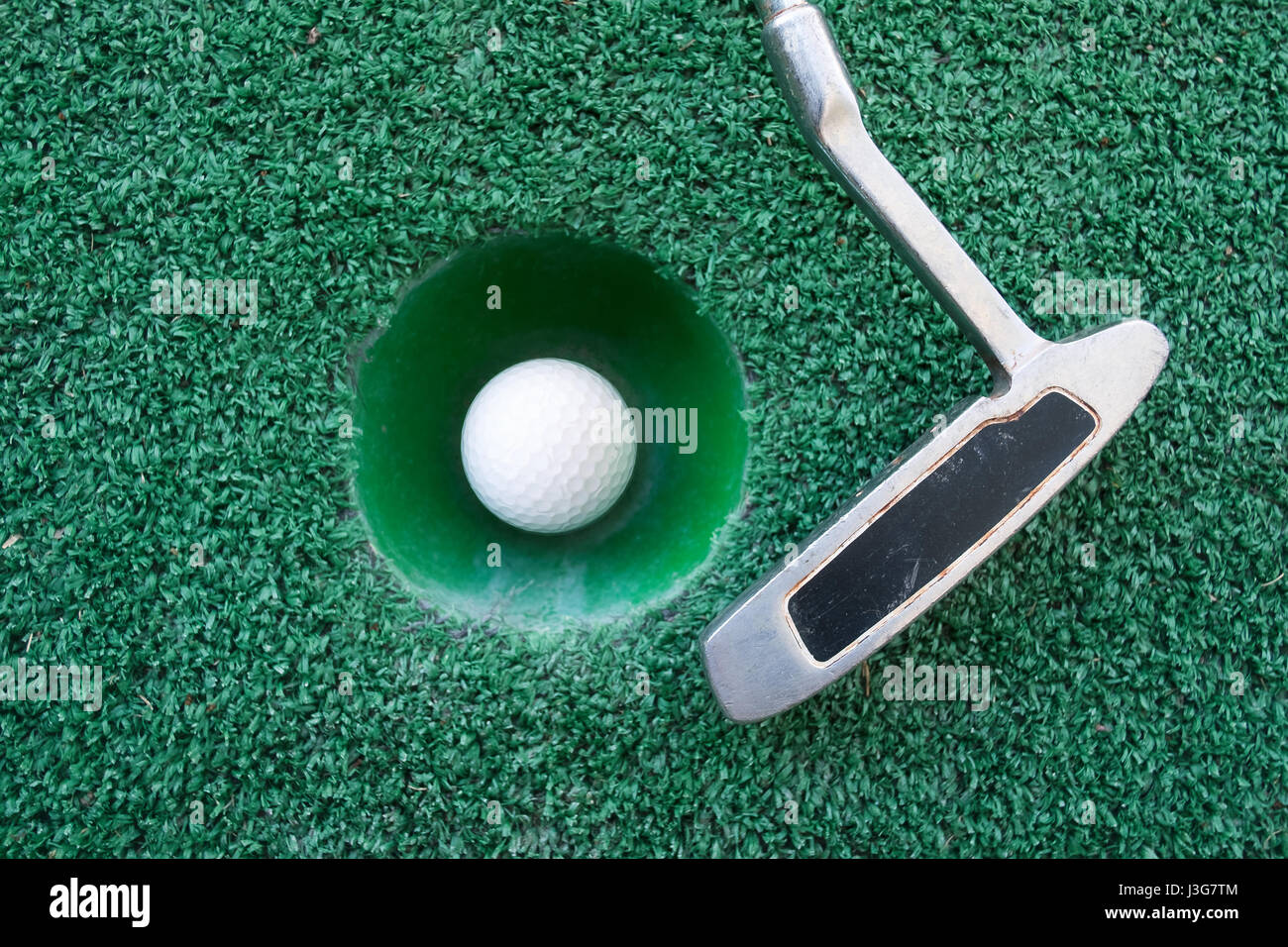 Mini golf scene with ball and club. Can be used like background. Sunny day at resort park Stock Photo