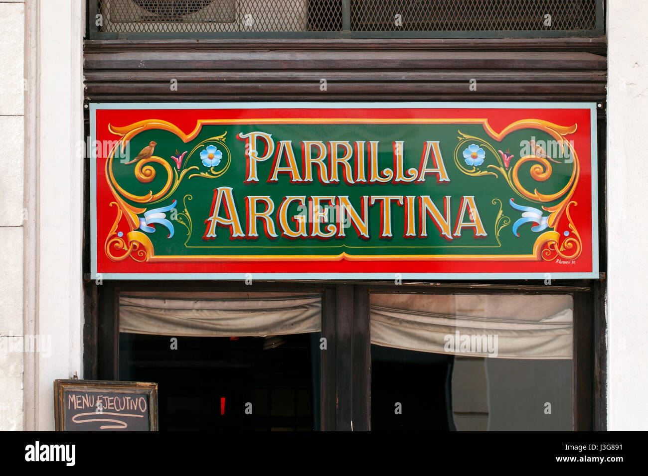Fileteado Porteño traditional hand lettering on a grill bar entrance in Defensa, Buenos Aires. Parilla. Stock Photo