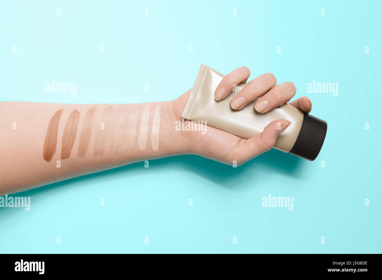 Foundation swatches on the hand holding makeup tube Stock Photo