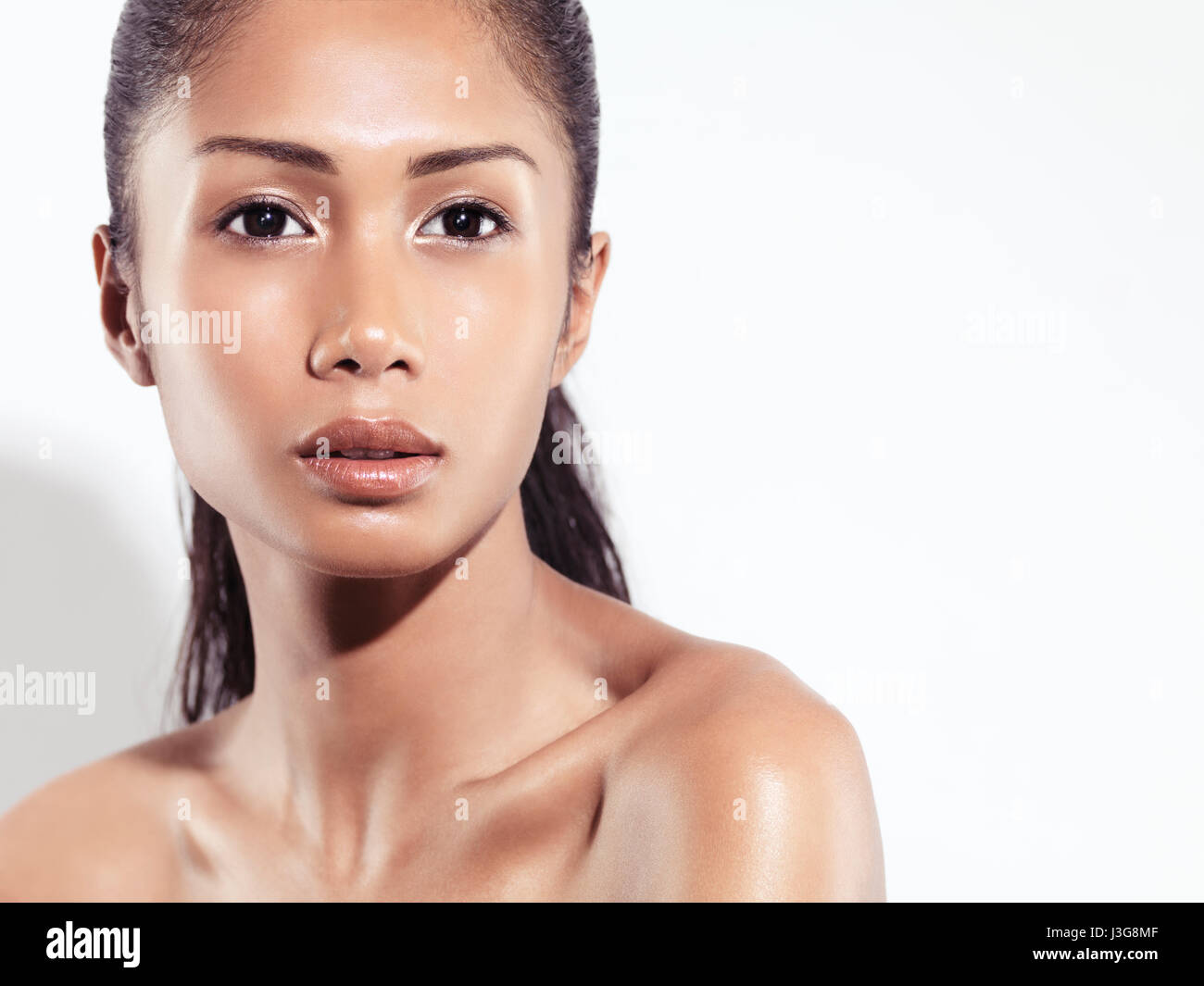 Closeup beauty portrait of an attractive young woman beautiful exotic asian face with healthy natural look isolated on white background Stock Photo