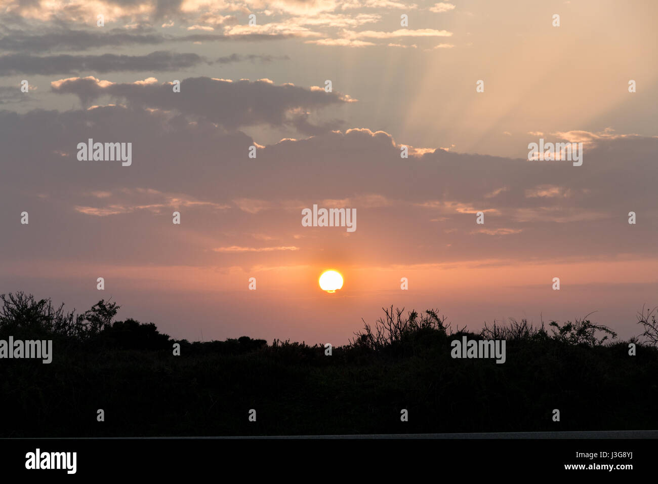 Sunset with clouds, light rays at Lagos, Algarve, Portugal Stock Photo