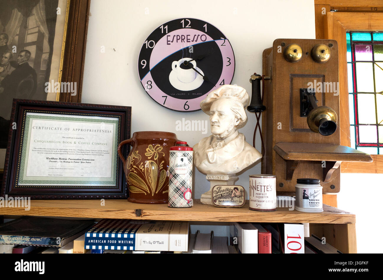 Shelf at coffee shop with espresso clock, old telephone, bust of Wagner, various jars, and certificate of appropriateness. Washburn Wisconsin WI USA Stock Photo