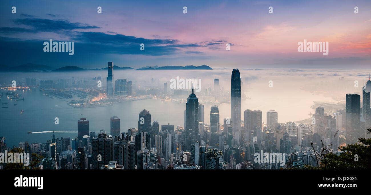 Misty City and Harbor at Sunrise - Victoria Harbor of Hong Kong Stock Photo