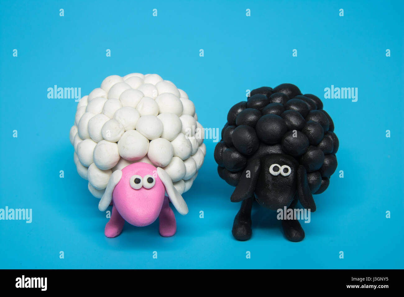 Concept - A black and a white polymer clay sheep placed next to each other Stock Photo