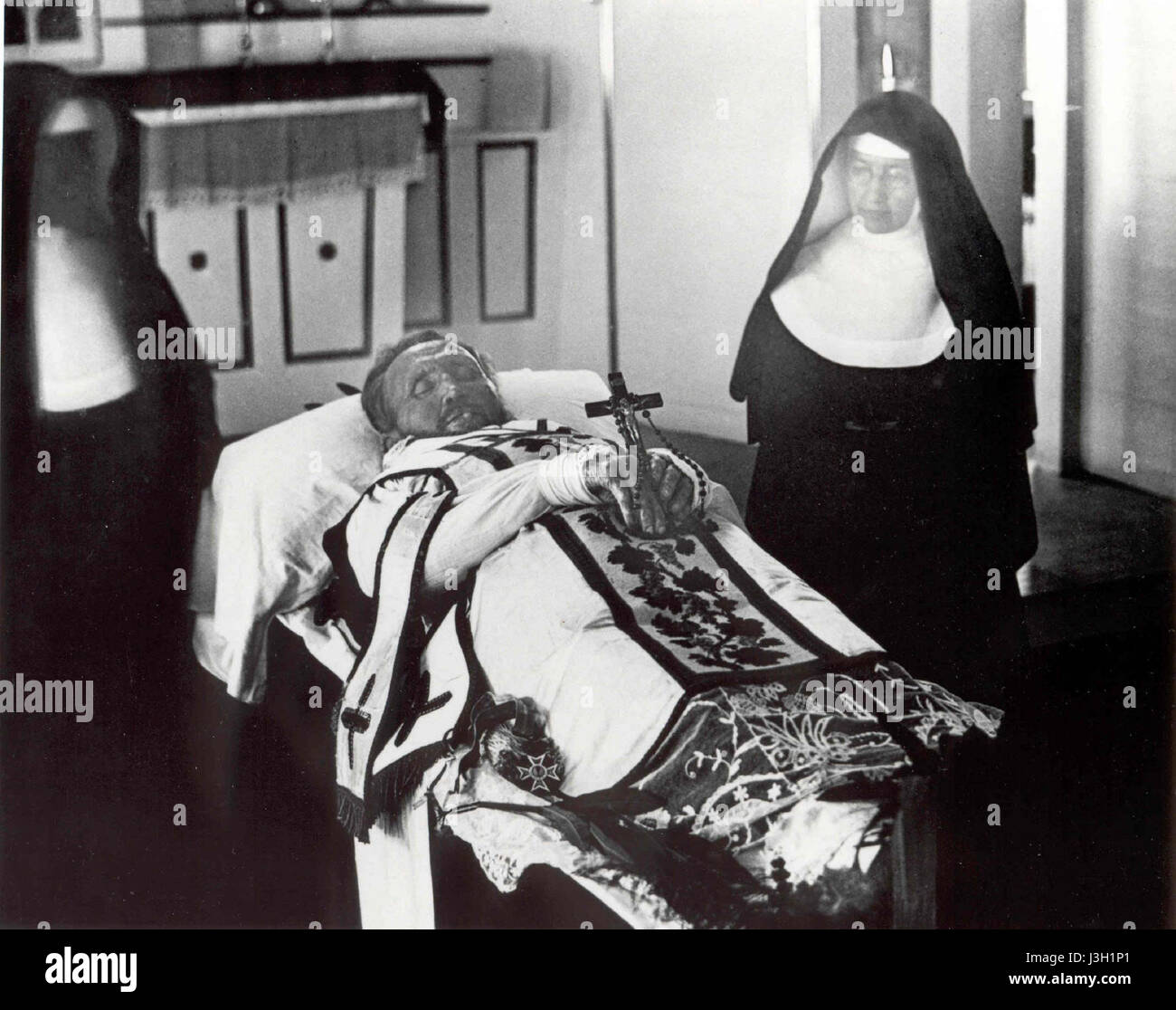 Father Damien on his funeral bier with Mother Marianne Cope by his side Stock Photo