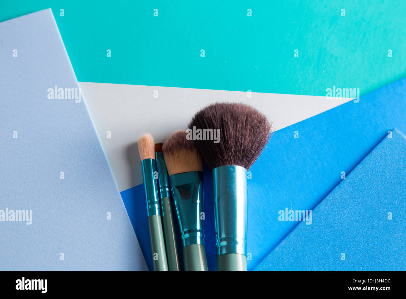 Her Life in Shades of Blue: Still Life of a make-up brush placed on a multi-tone shades of blue. Stock Photo