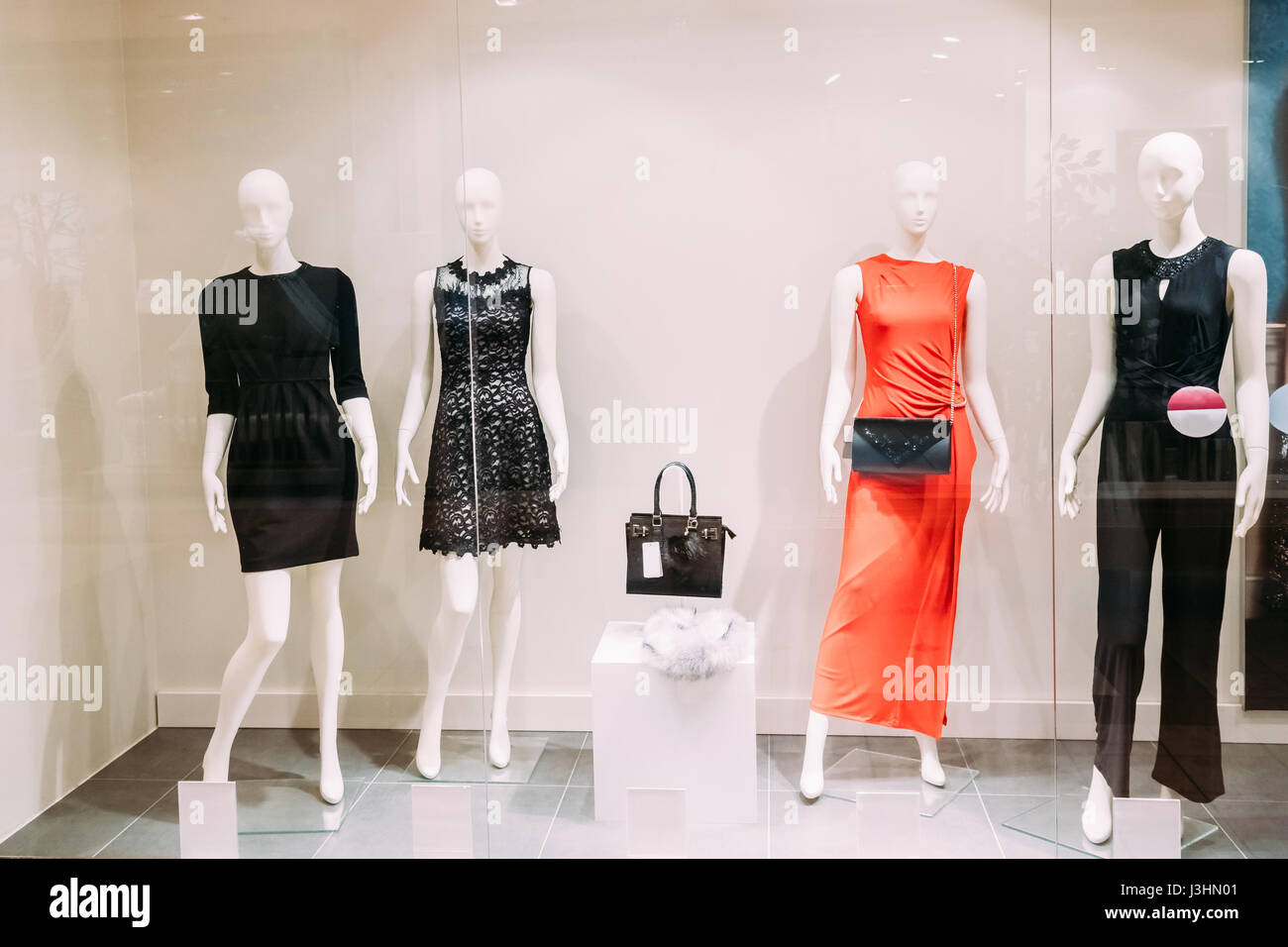 Four Mannequins Standing In Store Window Display Of Women's Casual Clothing Shop In Shopping Mall. Stock Photo