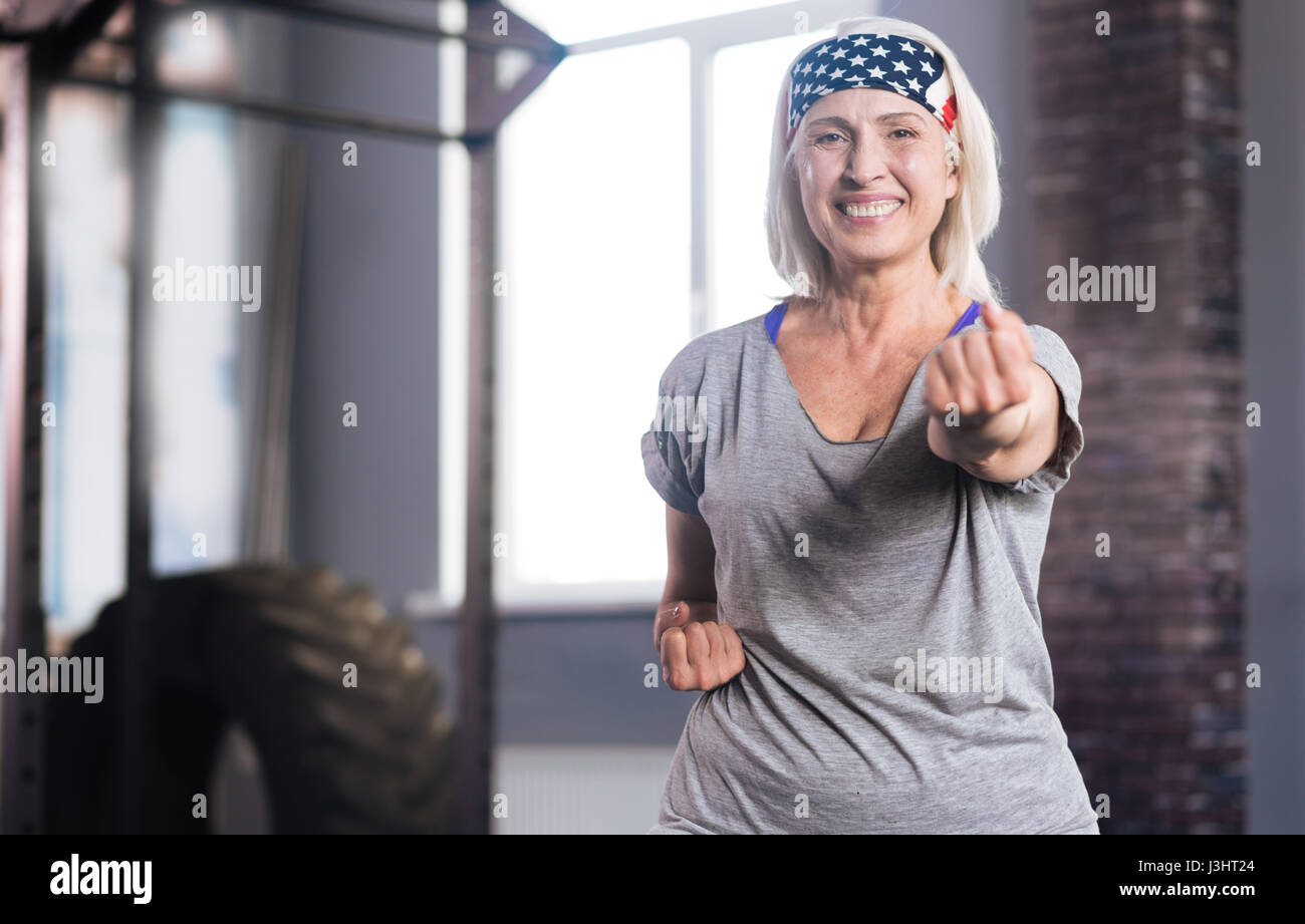 Self defence classes. Happy active senior woman clenching her fists and