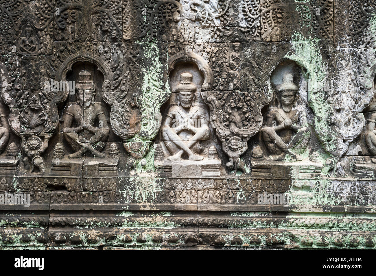 Row of ancient apsara dancers carved into weathered stone at the temple ruins of Angkor Wat in Siem Reap, Cambodia Stock Photo