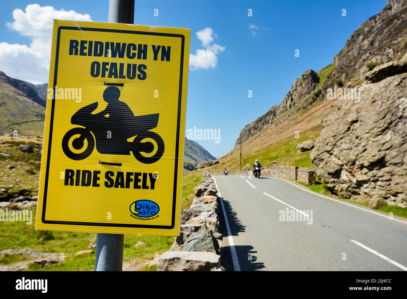 Bright yellow notice attached to clearway sign advising motorcyclists ...