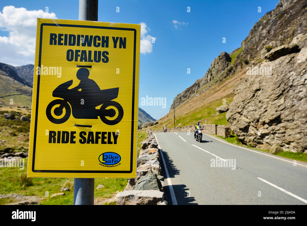 Bright yellow notice attached to clearway sign advising motorcyclists ...