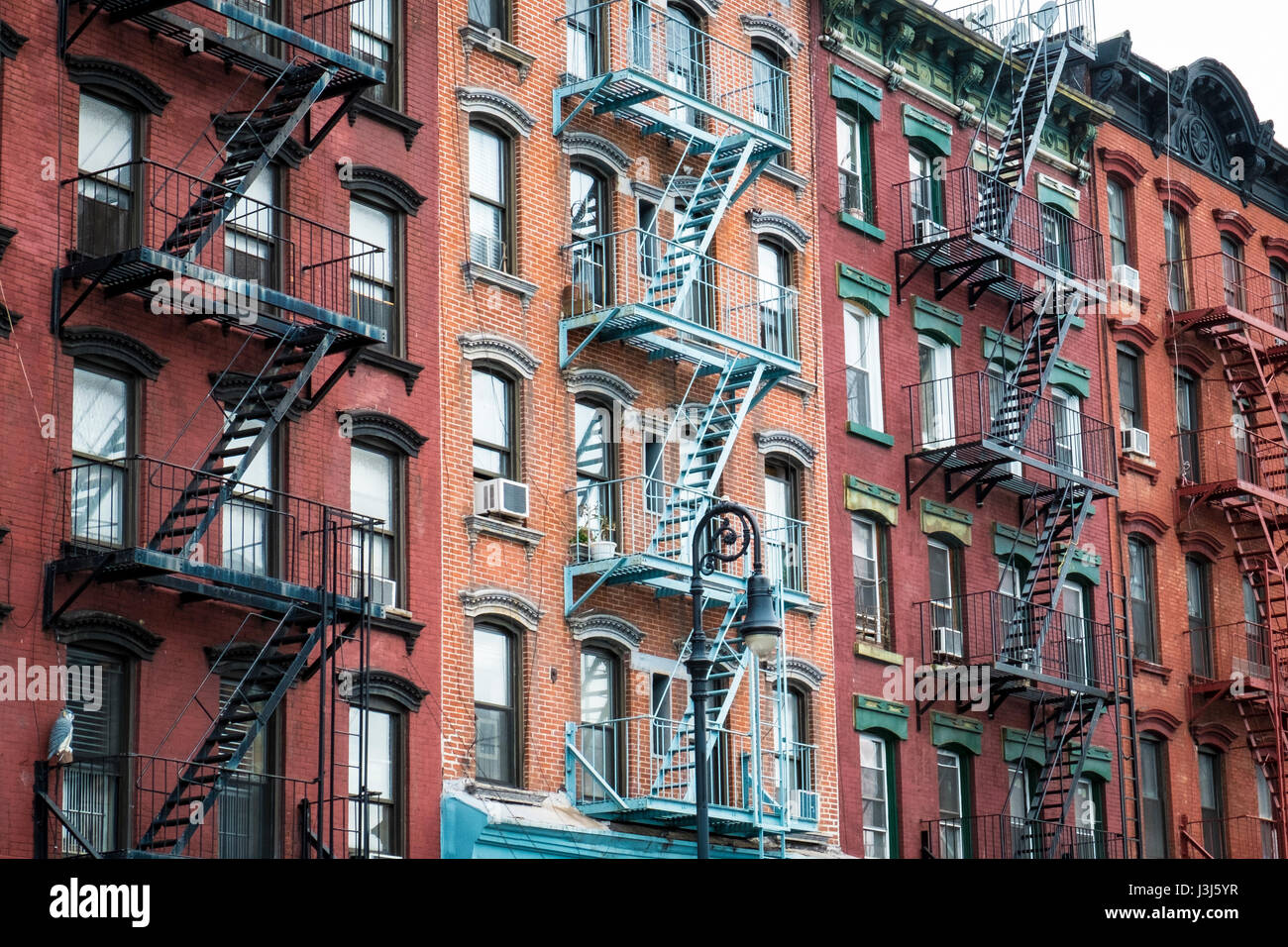 Red brick apartment building with fire escape in New York city Stock