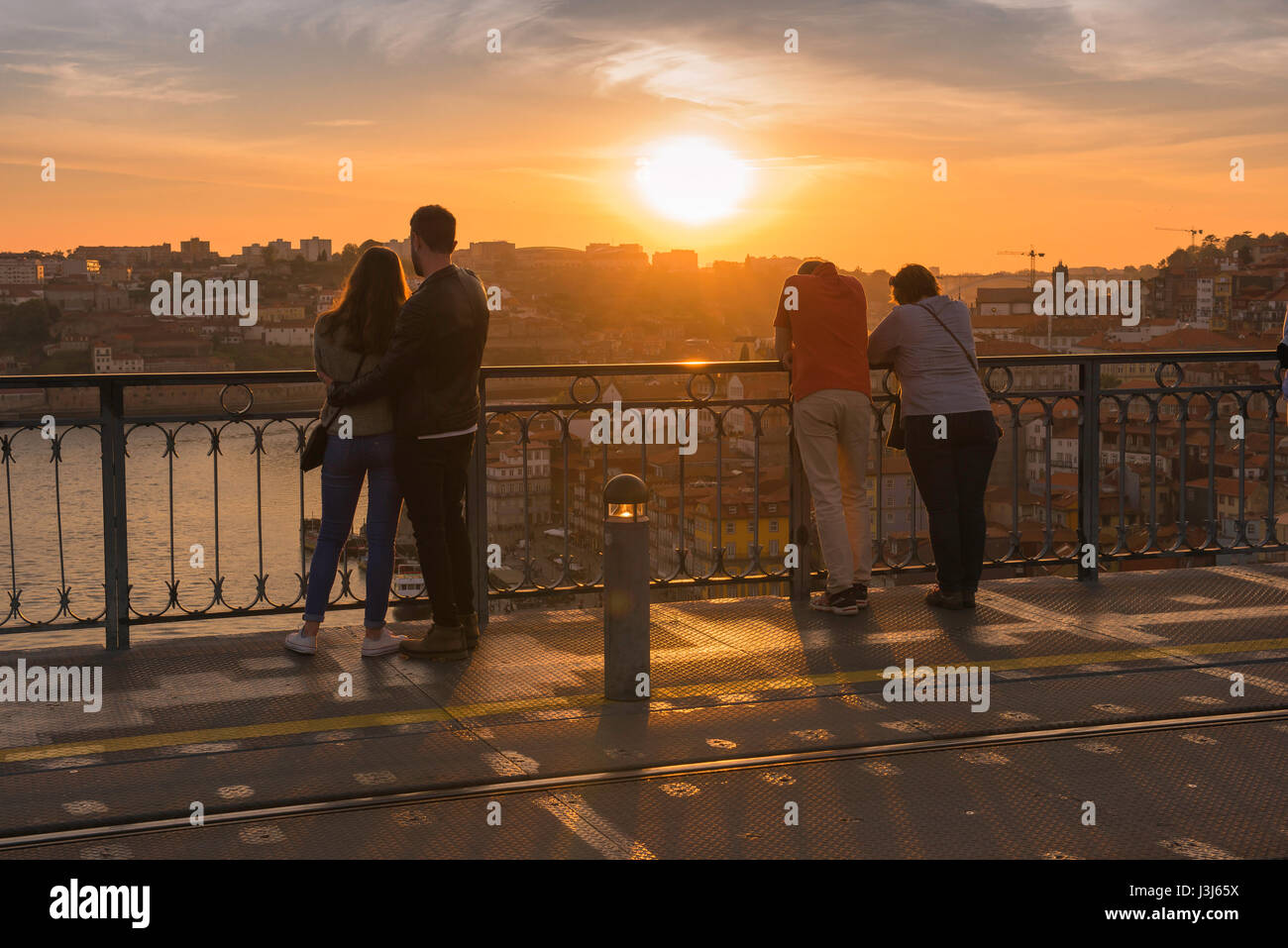 Tourists Porto Portugal, view of couples standing on the Ponte Dom Luis I bridge and watching a sunset over the city of Porto, Portugal, Europe Stock Photo
