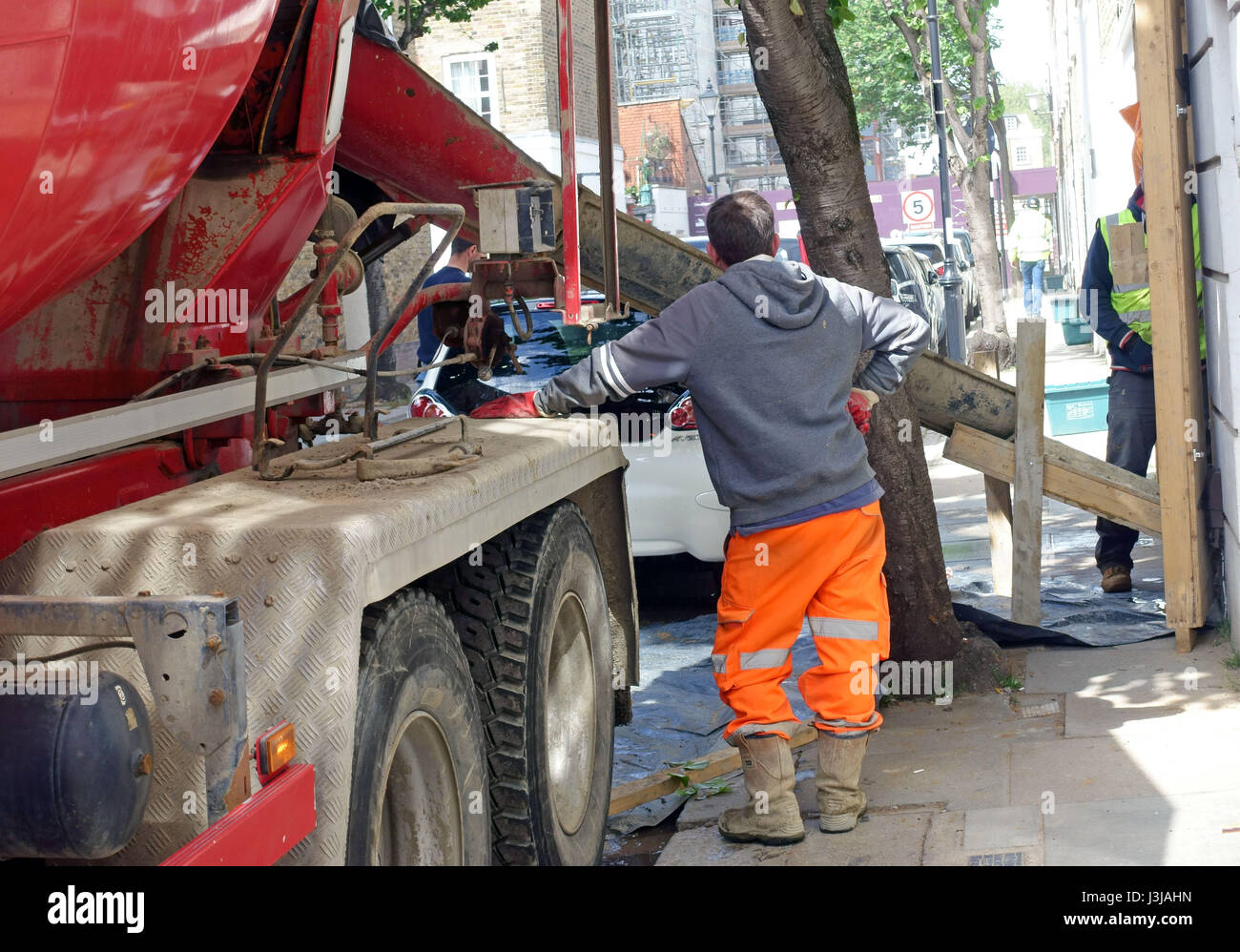 Ready mix concrete being delivered to basement excavation under house