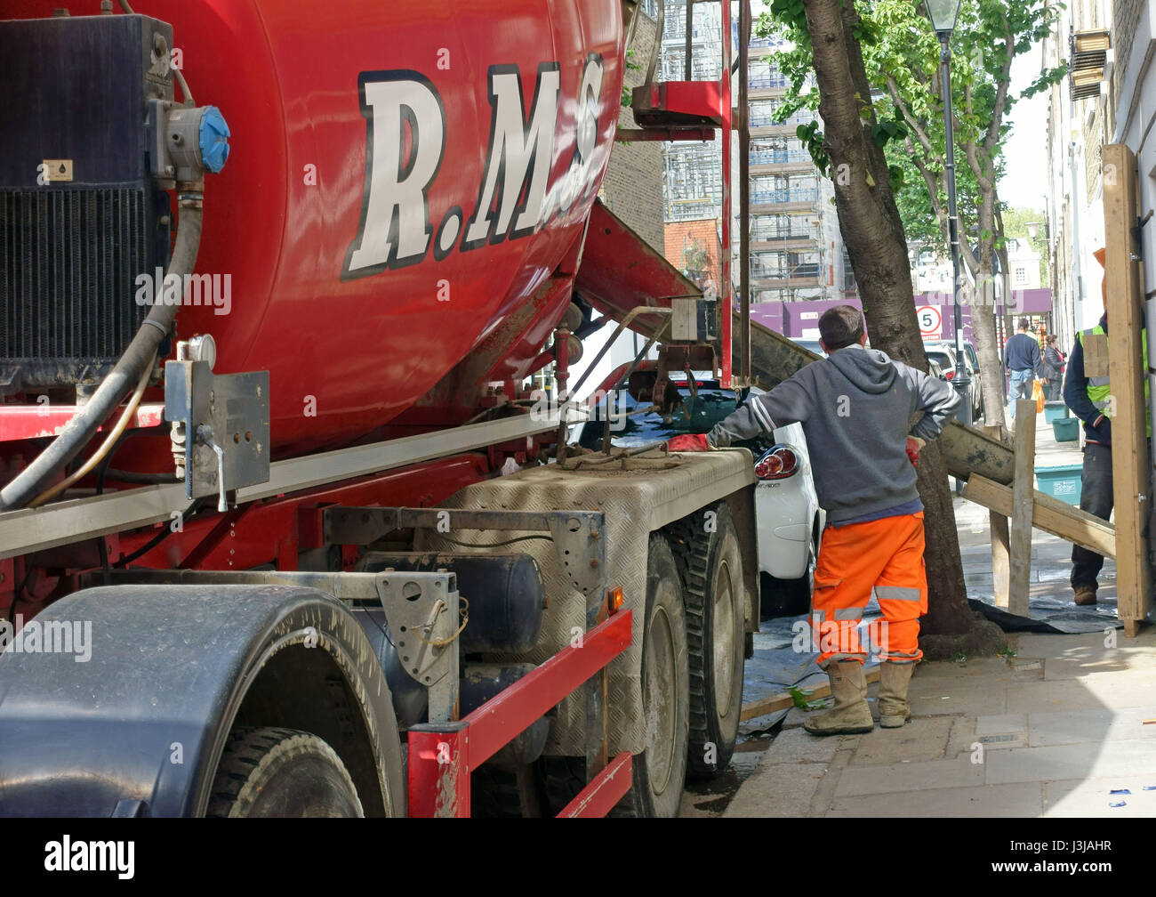 Ready mix concrete being delivered to basement excavation under house