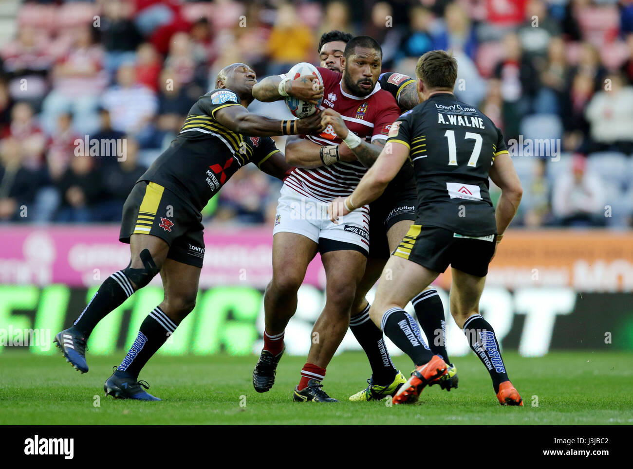 Wigan Warriors' Frank-Paul Nuuausala is tackled by Salford's Robert Lui, Adam Walne and Ben Murdoch-Masila during the Betfred Super League match at The DW Stadium, Wigan. Stock Photo