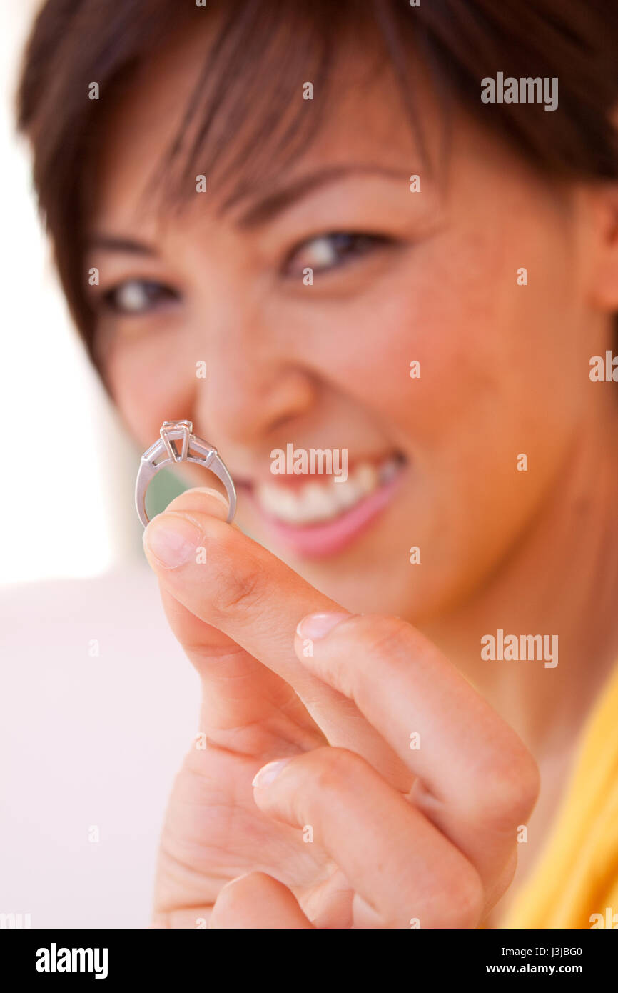 Asian woman smiling showing her engagement ring. Stock Photo