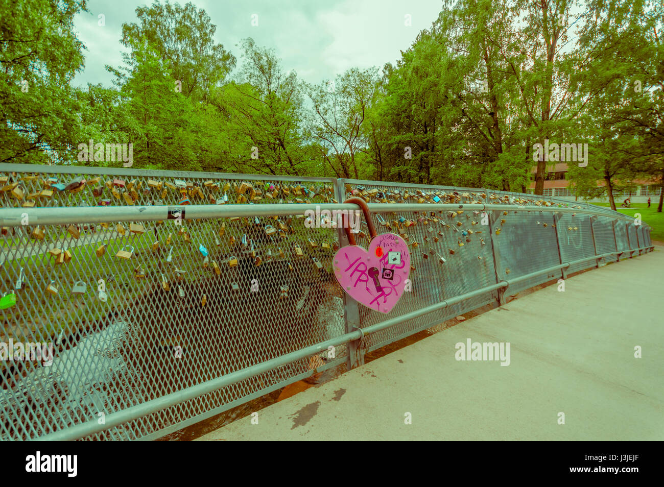 OSLO, NORWAY - 8 JULY, 2015: Alongside Akerselva river passing through city, bridge with many locks hooked as declarations for love. Stock Photo