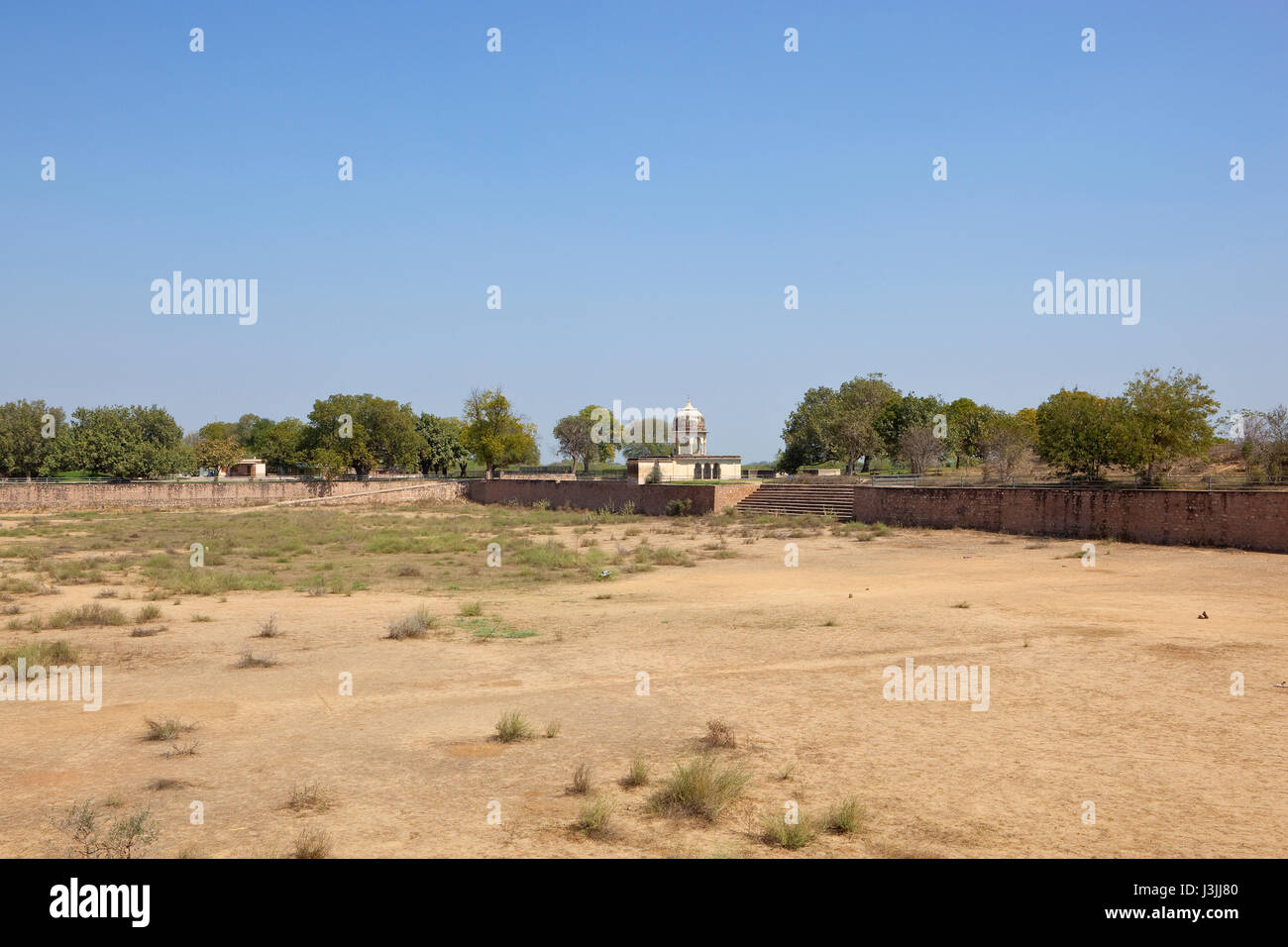 a dry sandy sarovar at the historical place of jal mahal in north india under a blue sky Stock Photo