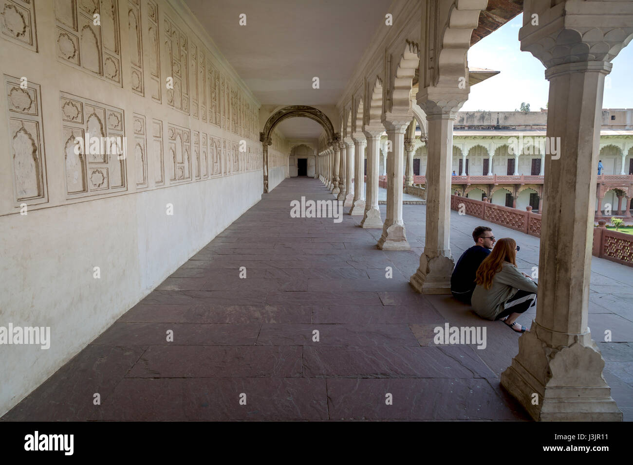Tourists enjoy a moment in solitude in the corridor of Agra Fort. Agra Fort being a world heritage site is a primary tourist attraction at Agra, India Stock Photo