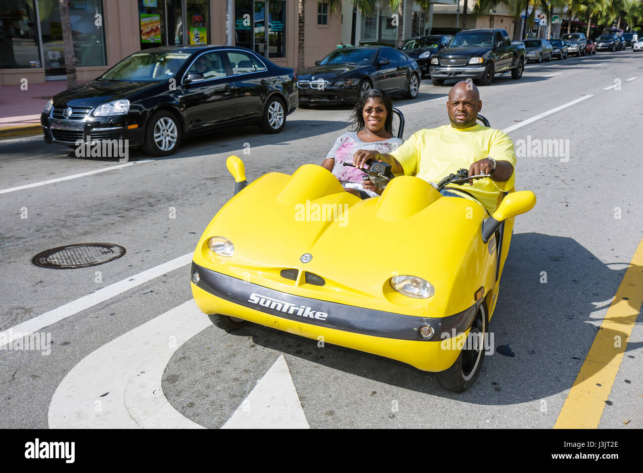 Miami Beach Florida,Washington Avenue,rental,three wheel,three 3 wheel,Black man men male,woman female women,couple,vacation,vehicle,Suntrike gas scoo Stock Photo