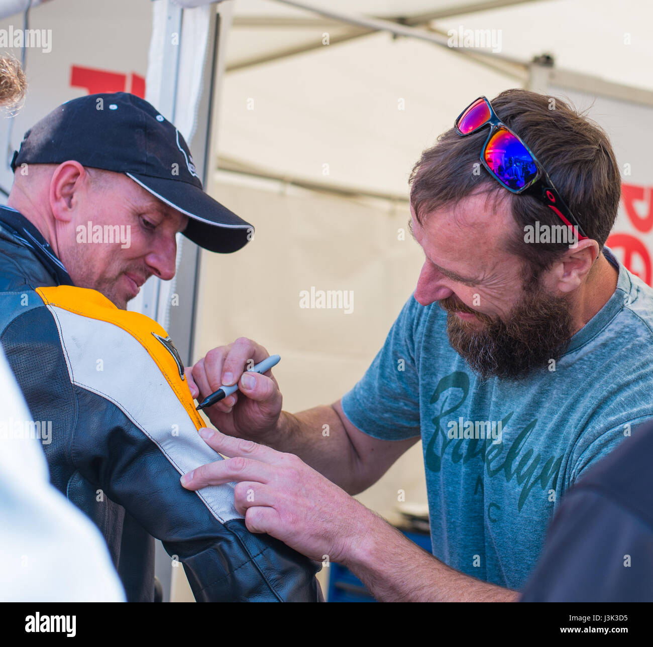 Bruce Anstey signing autograph for the fan at Manx Grand Prix Stock Photo