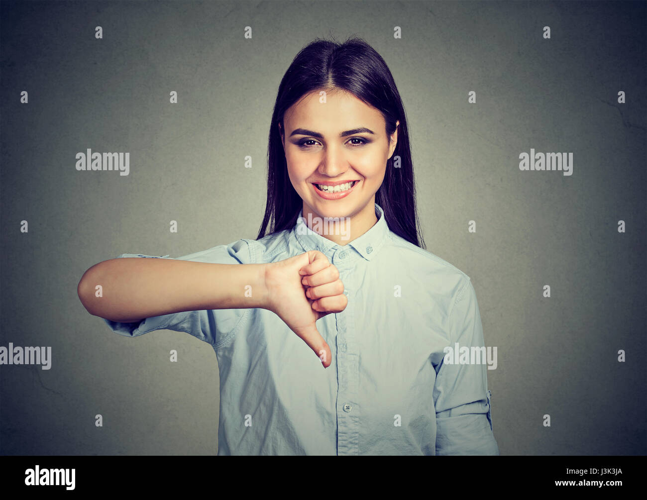 Smiling woman showing thumbs down Stock Photo Alamy