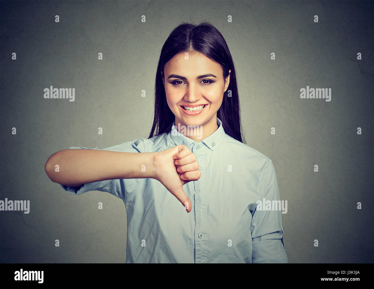 Smiling woman showing thumbs down Stock Photo