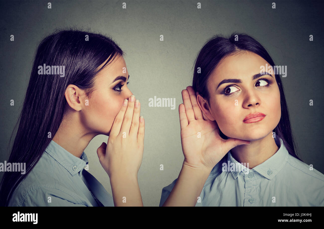 Latest rumors. Woman whispering in the ear to herself Stock Photo