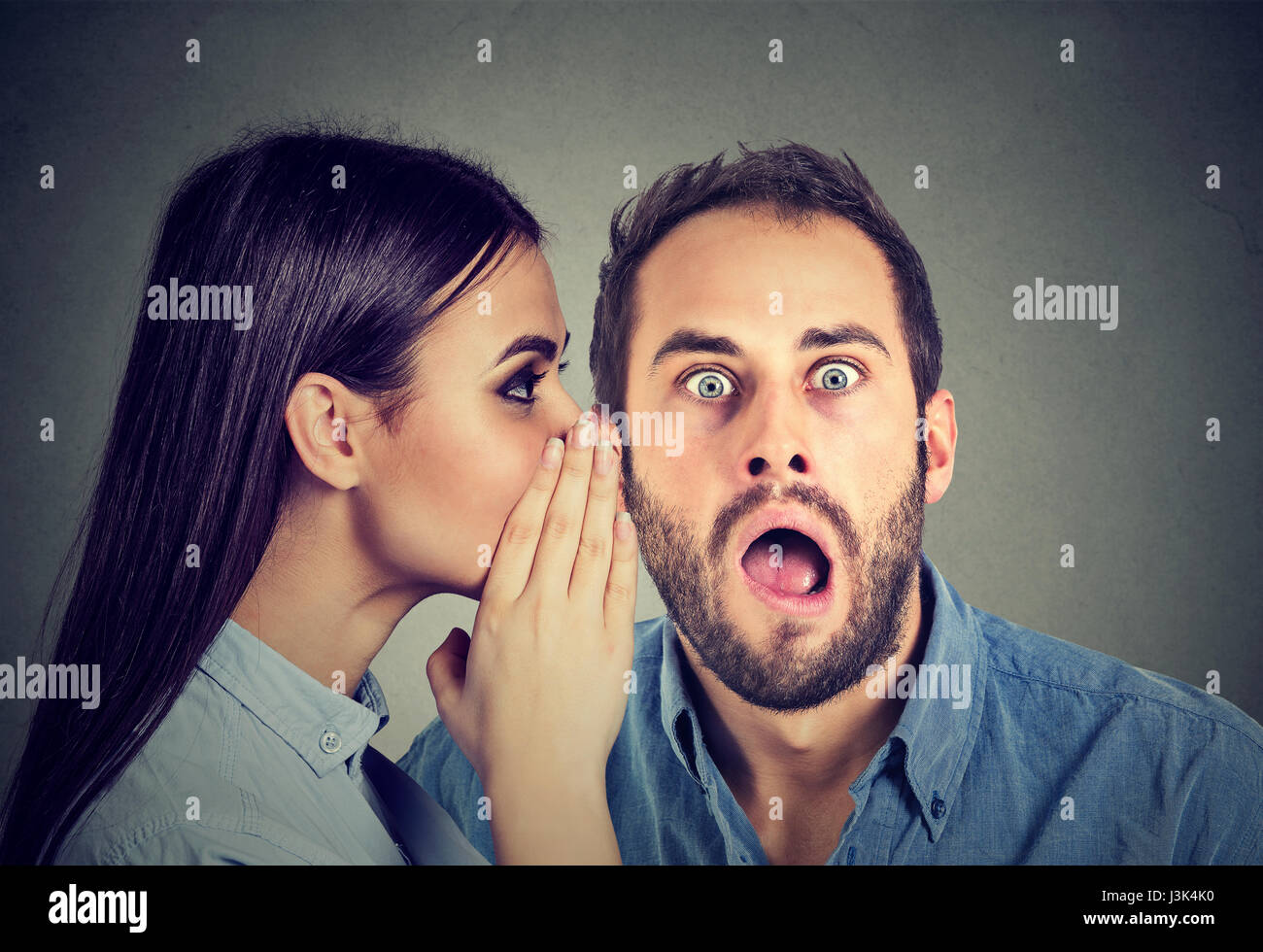 Latest rumors. Amazed man listening gossip in the ear Stock Photo