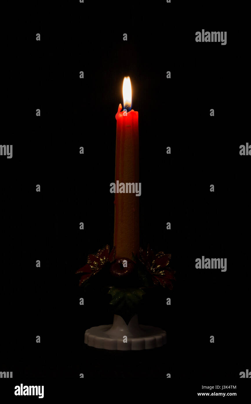 Lit candle on black background Stock Photo