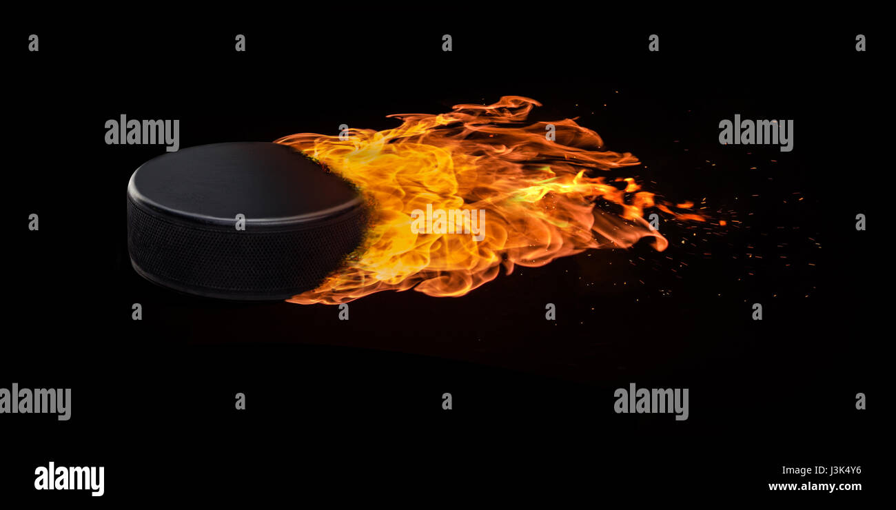 Flying hockey puck engulfed in trailing flames with sparks flying on a black background. Concept
