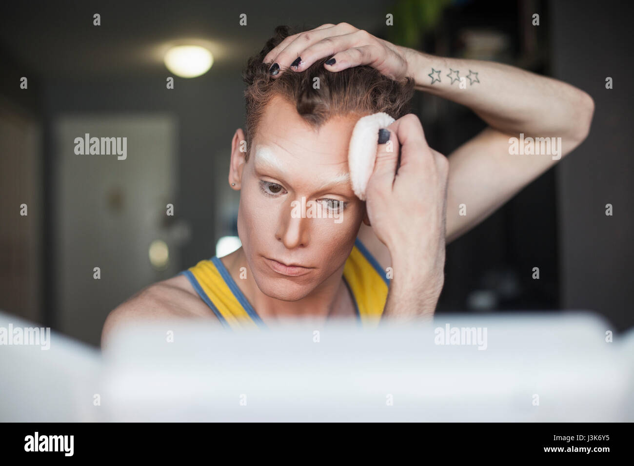 Young man applying drag makeup Stock Photo