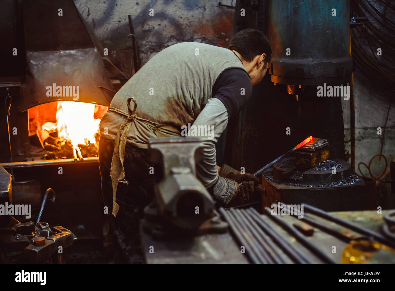 blacksmith working in the forge on auto hammer Stock Photo - Blacksmith Working In The Forge On Auto Hammer J3K92W