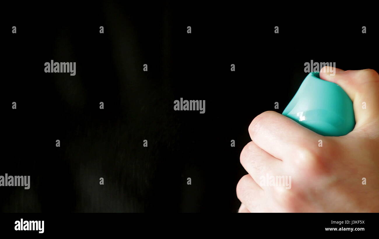 Aerosol can being sprayed against a black background Stock Photo - Alamy