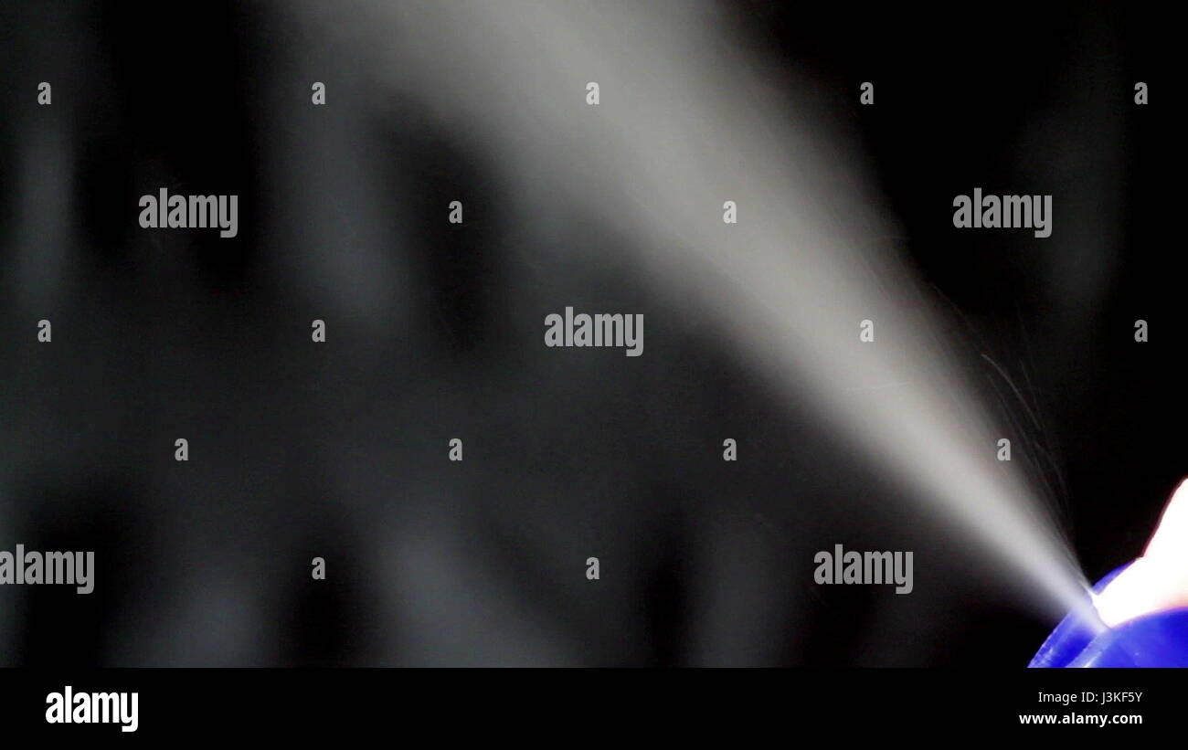 Aerosol can being sprayed against a black background Stock Photo - Alamy